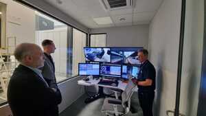 Po lewej stronie zdjęcia przedstawiciele start-up’u Nevomo w centrum sterowania symulatorami. Przed nimi monitory na których wyświetlany jest obraz z kabiny symulatorów.