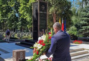 Wiceprezes Urzędu Transportu Kolejowego, Marcin Trela składający biało czerwone kwiaty przed Pomnikiem Gloria Victis na Cmentarzu Wojskowym na Powązkach